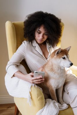 Woman sitting in yellow chair with her hairy pet dog